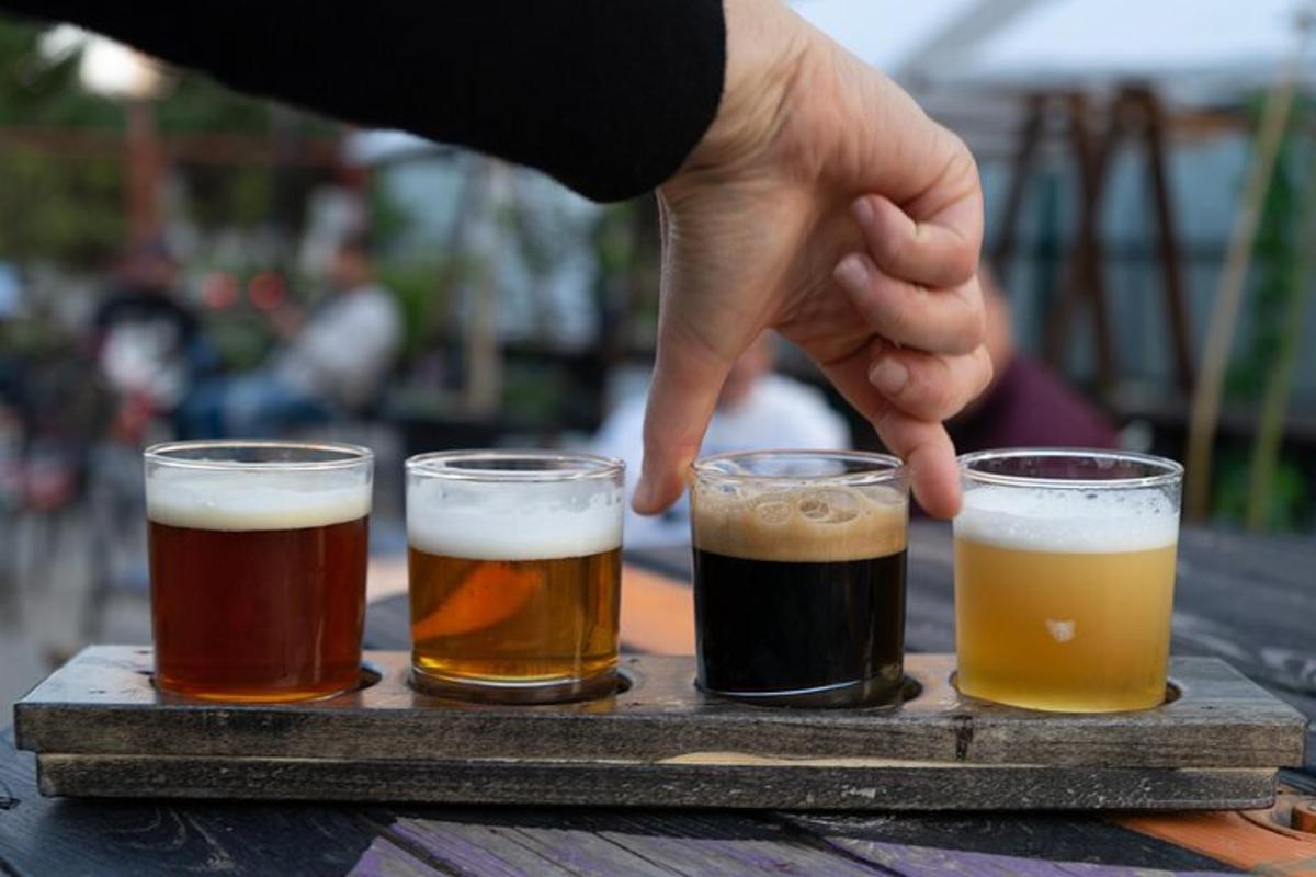 trīs glāzes alus uz koka paplātes