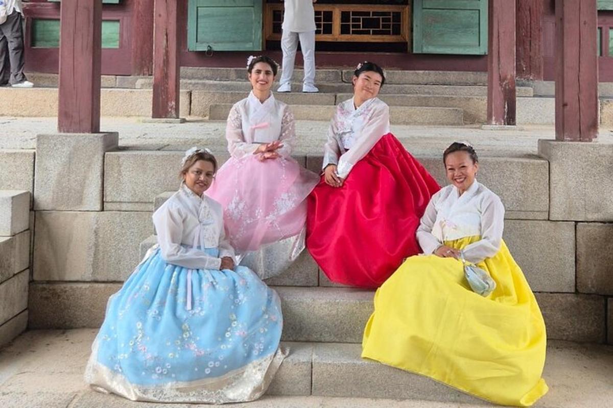 Cuatro chicas jóvenes con vestidos sentadas en los escalones
