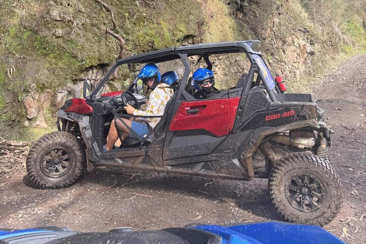 tři lidé jedoucí ve čtyřkolce na nezpevněné cestě