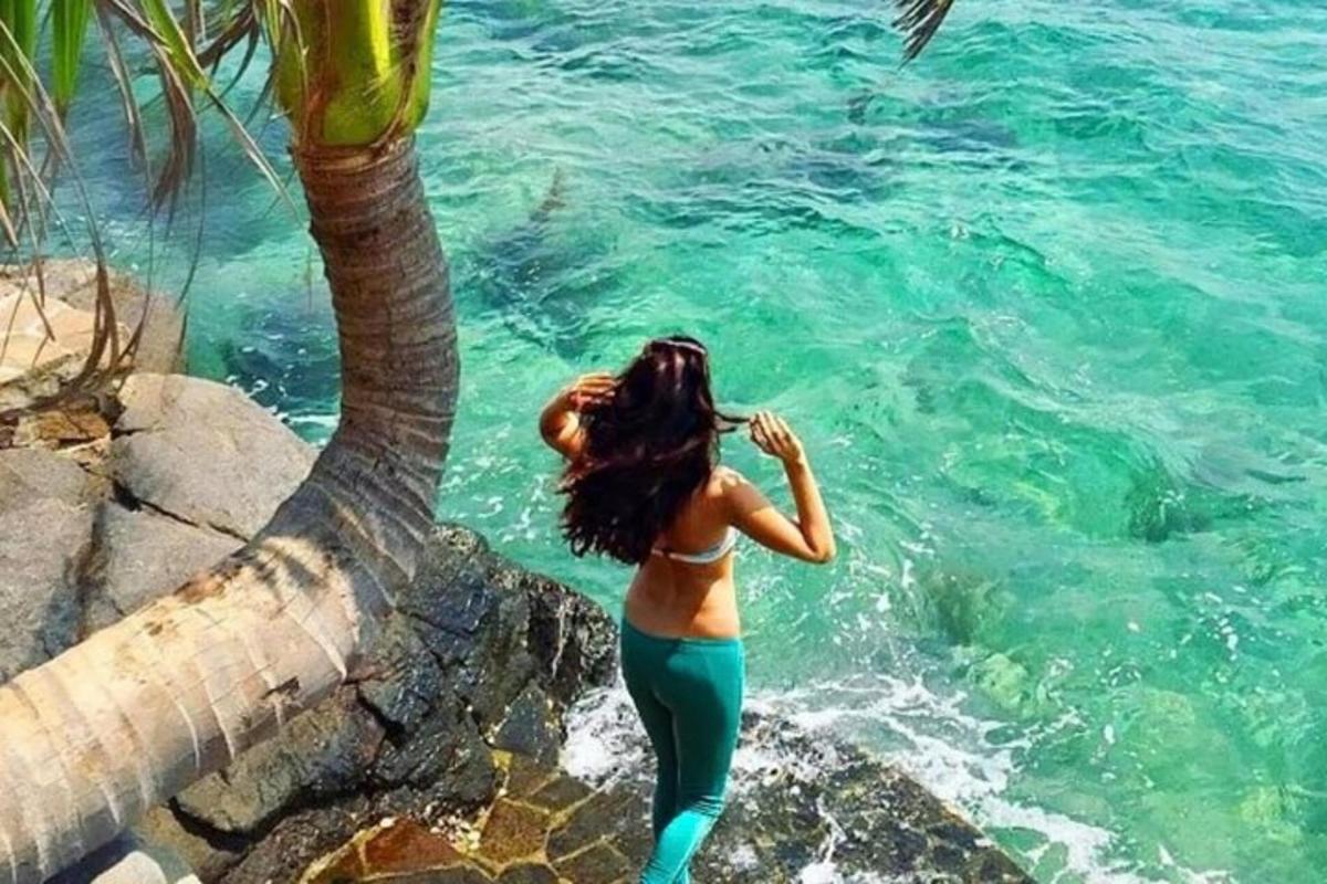 một người phụ nữ đứng trên một tảng đá gần mặt nước