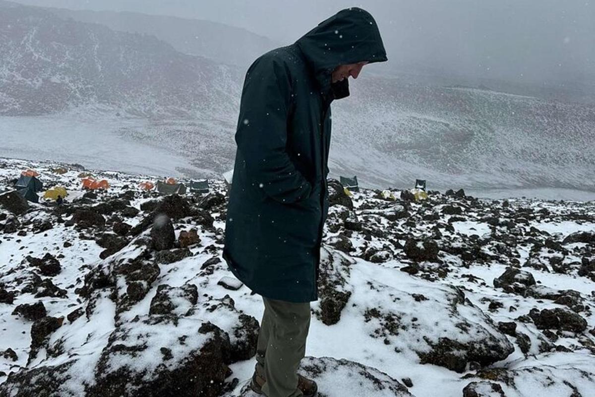 человек стоит на вершине заснеженной горы
