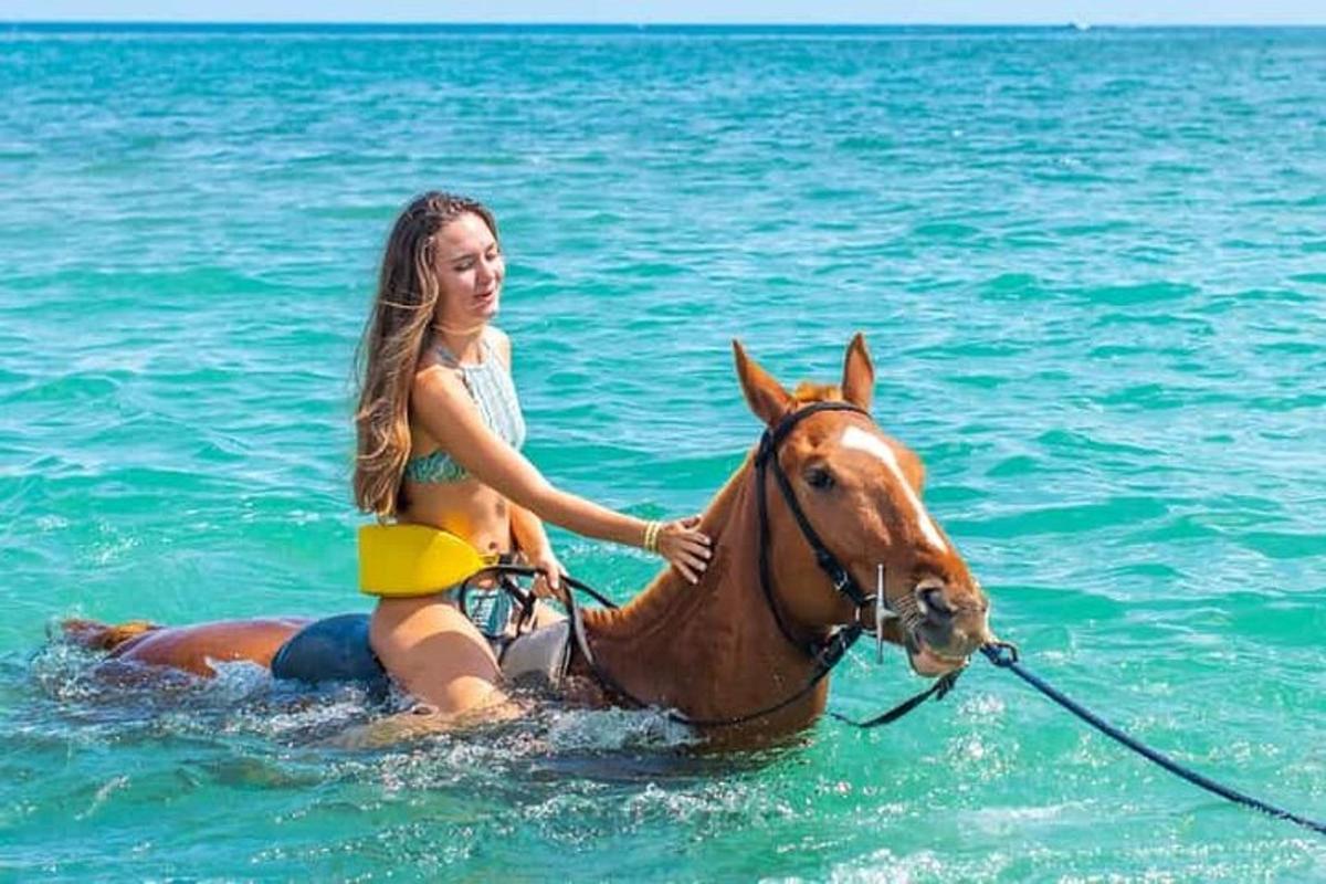 mladá dívka jedoucí na koni v oceánu