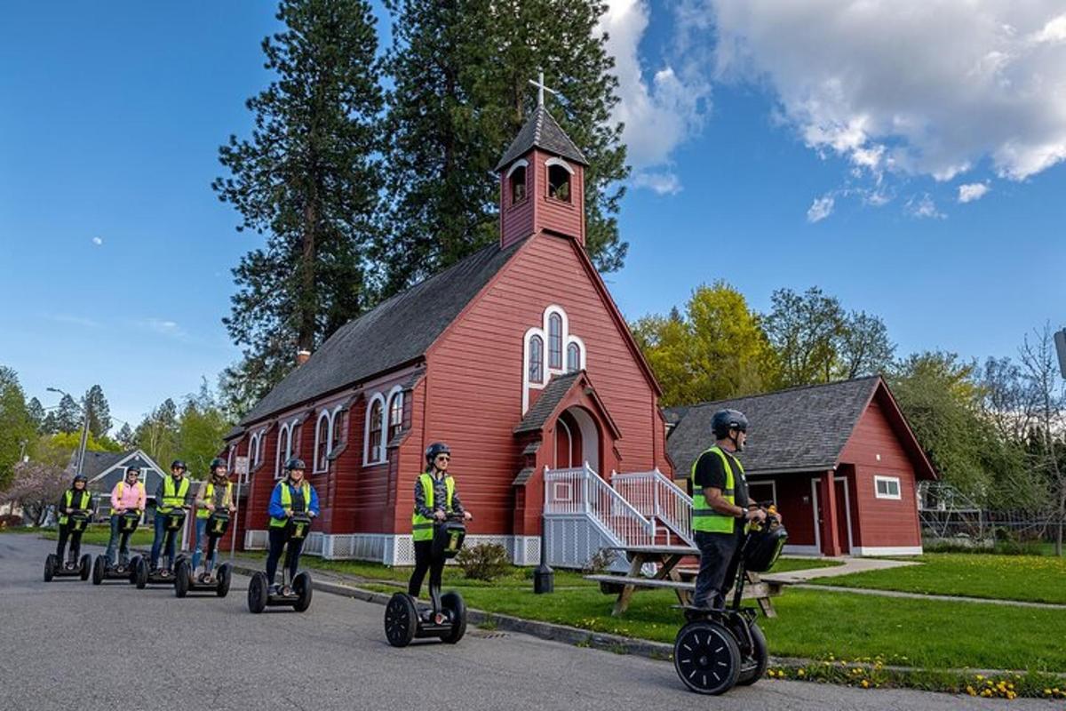 Skupina lidí jedoucích na segwayích před kostelem