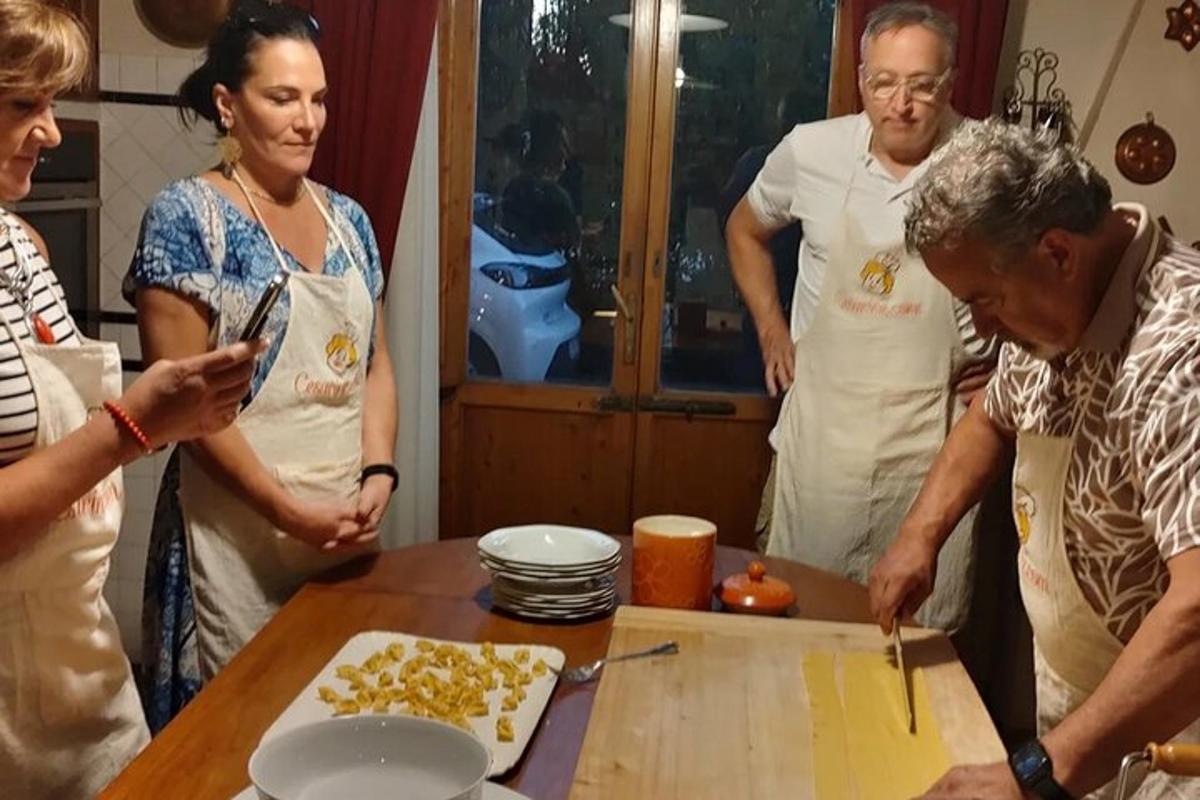 skupina ljudi, ki stojijo okoli mize v kuhinji