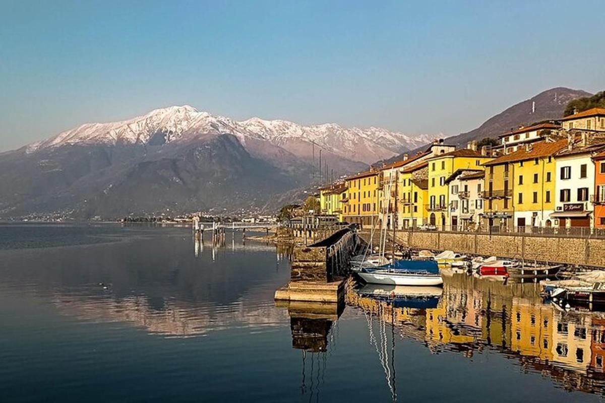 a body of water with boats and buildings and mountains