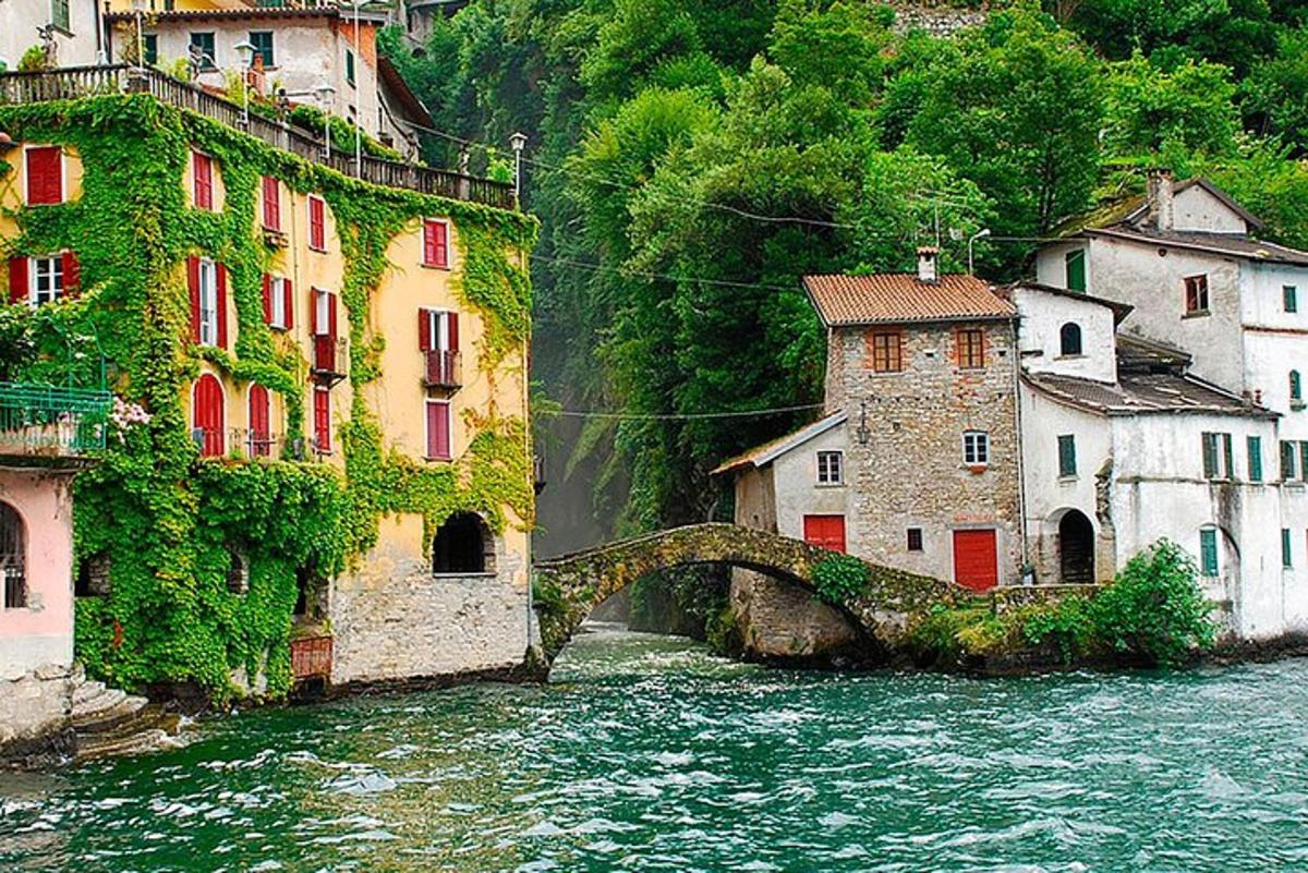 a group of buildings next to a river with a bridge