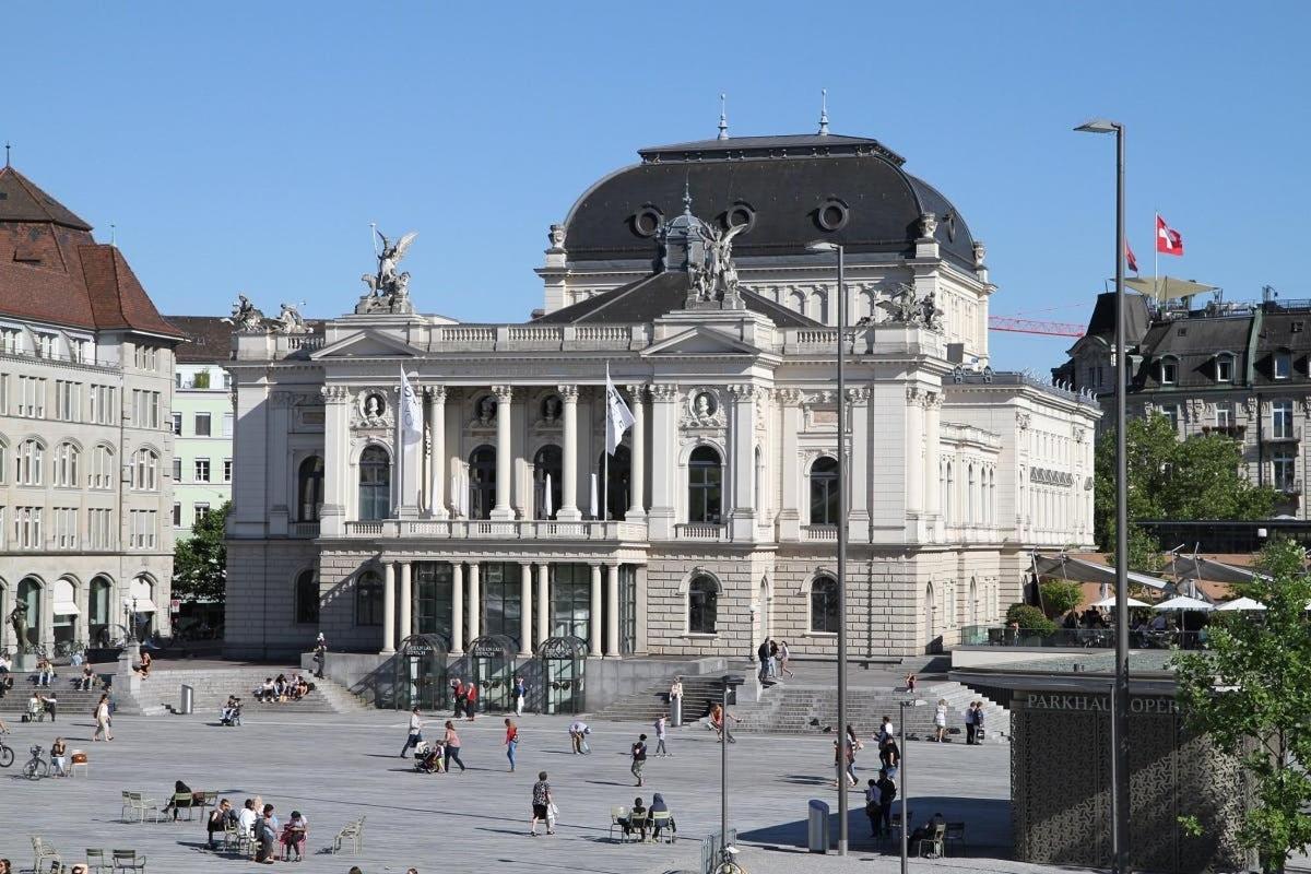 a large building with people sitting in front of it