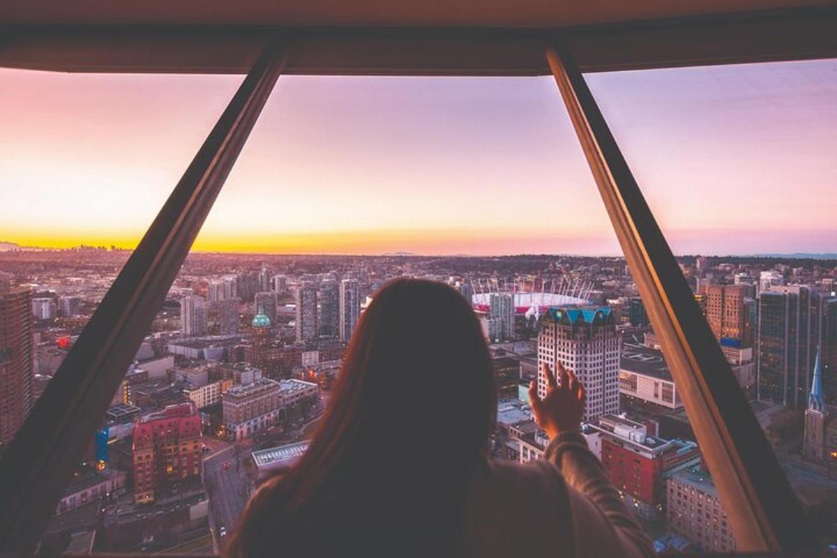 een vrouw die uit een raam naar de stad kijkt