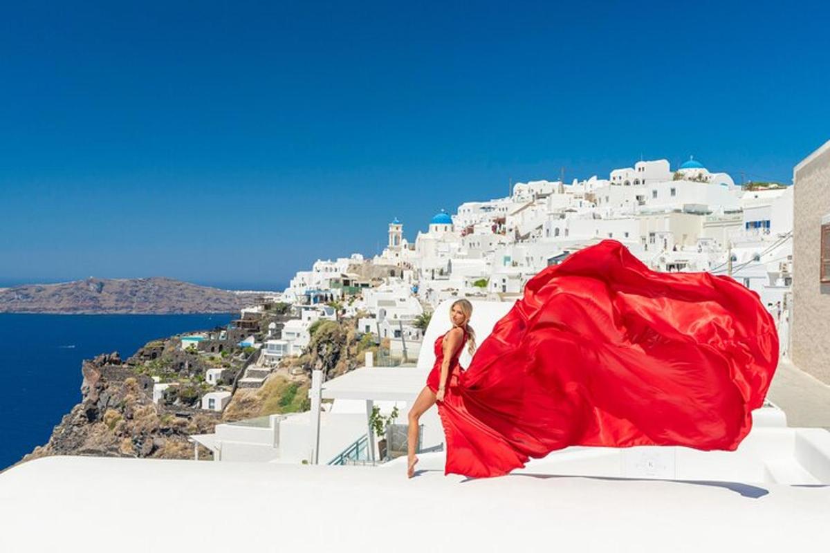 una dona amb un vestit vermell dempeus a dalt d'un edifici blanc