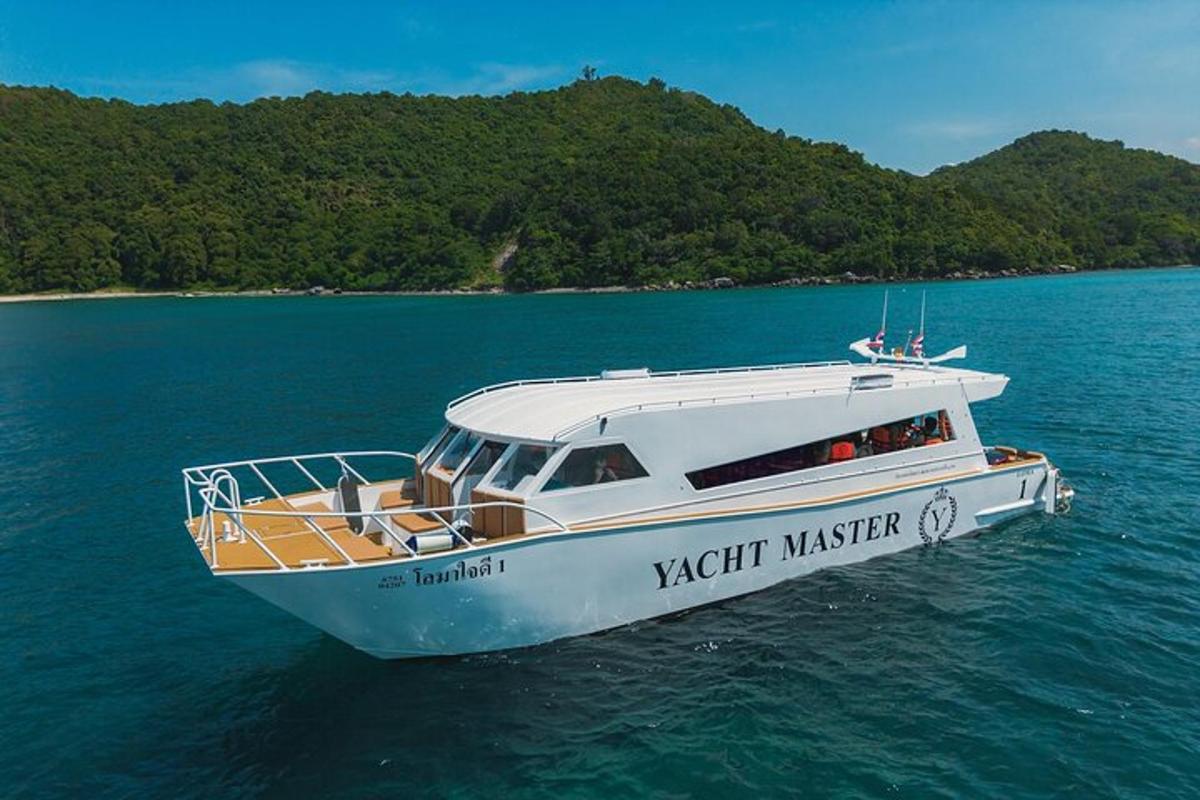 una barca bianca che galleggia nell'acqua vicino a un'isola