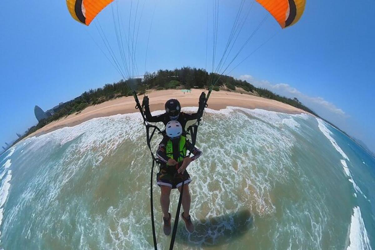 a man flying a kite in the water on the beach