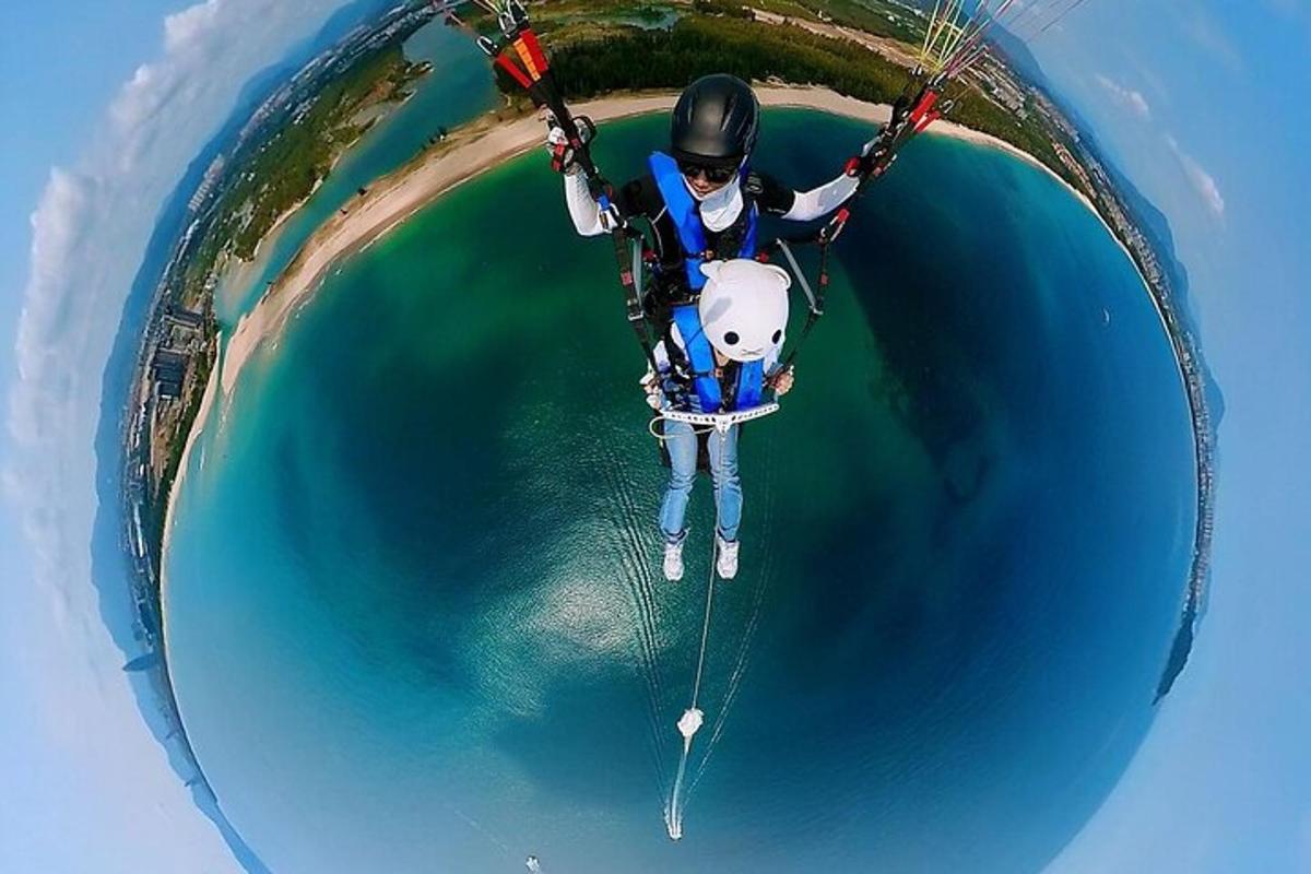 a person is hanging from a parachute over the water