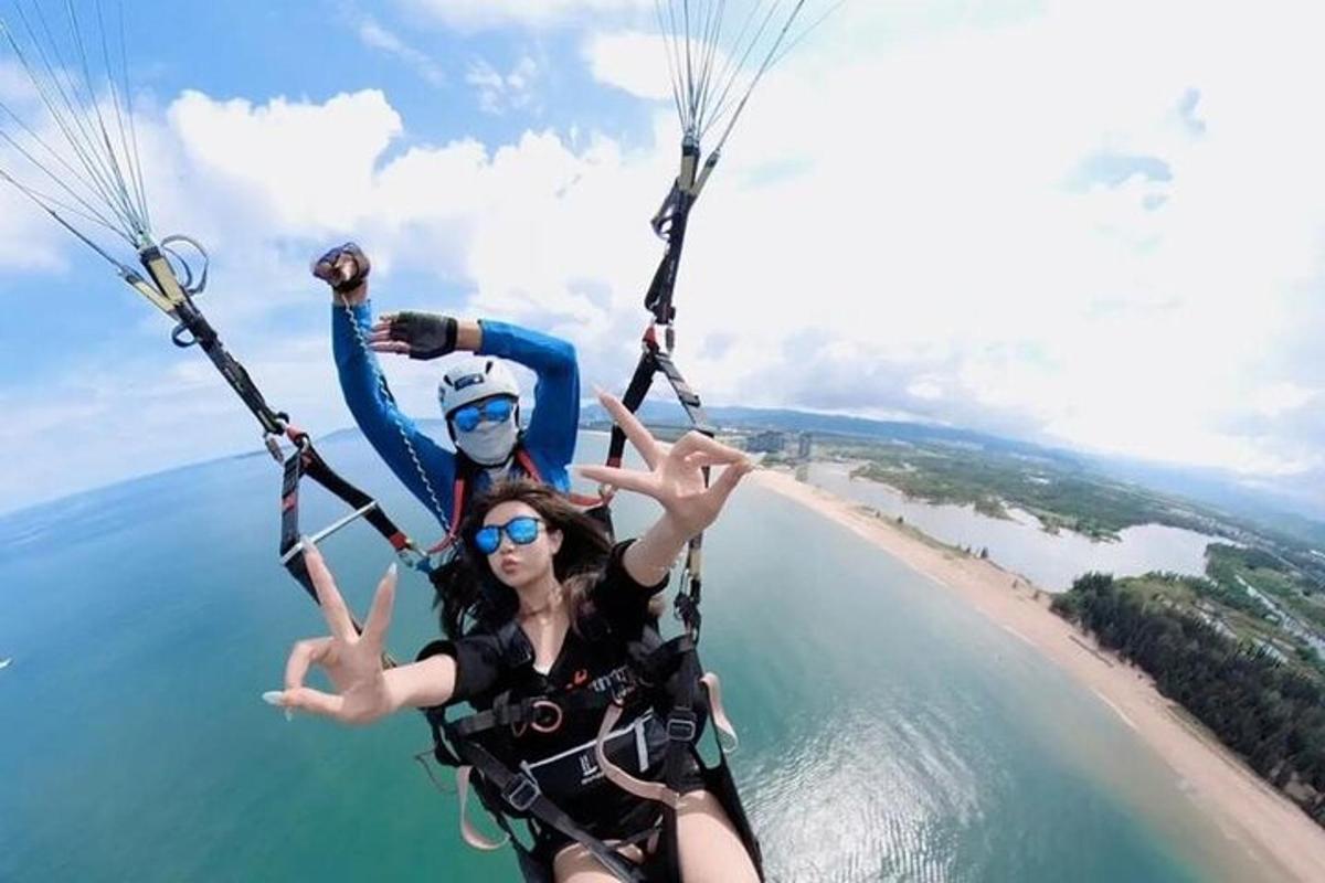 two people are riding on a parachute over the water