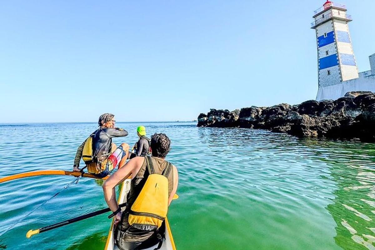 tre persone in kayak in acqua vicino a un faro
