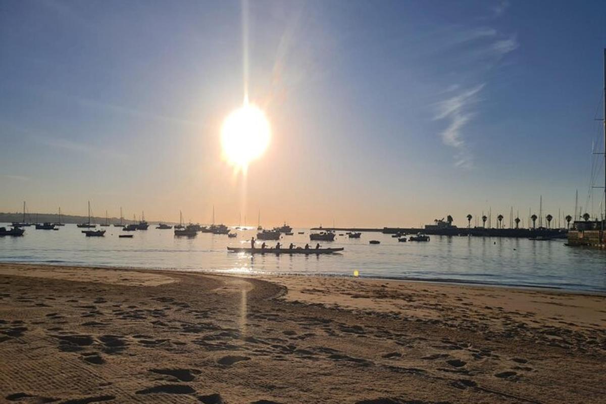 un sole che sorge su uno specchio d'acqua con barche