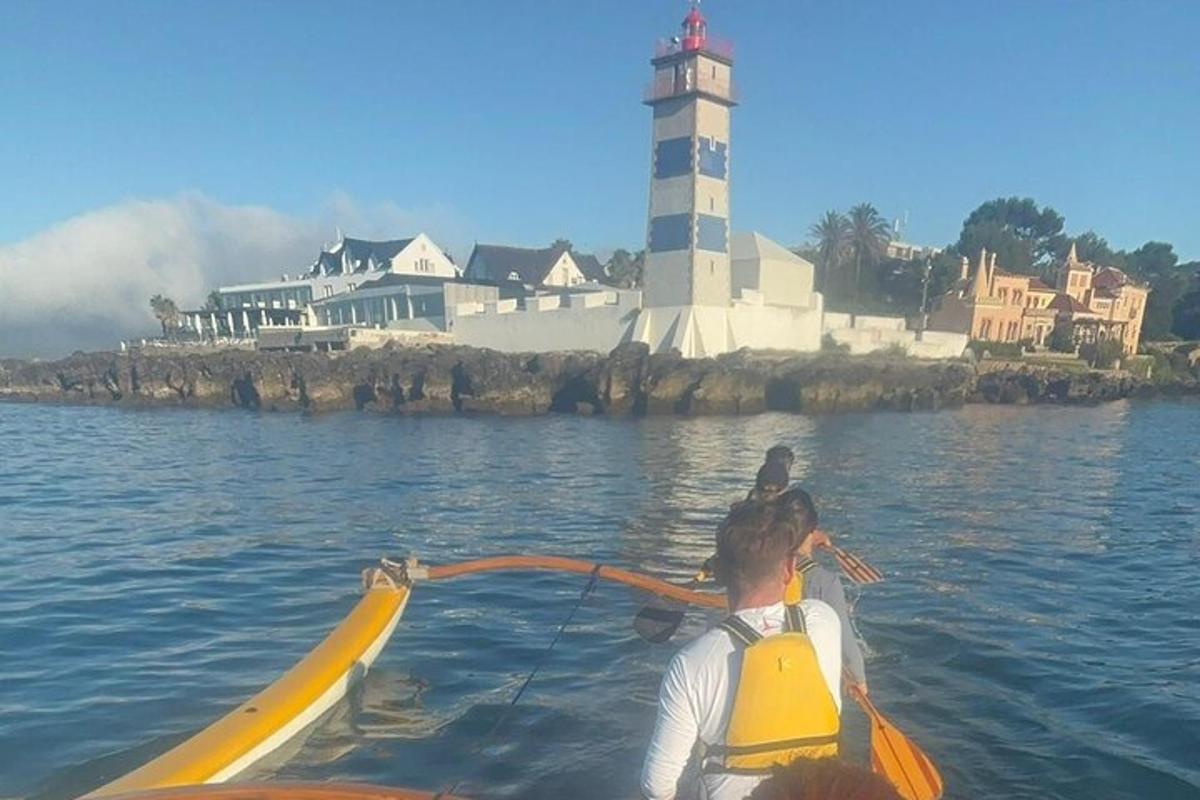 un gruppo di persone su una barca in acqua con un faro