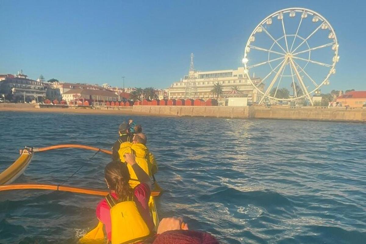 un gruppo di persone su una barca in acqua con una ruota panoramica