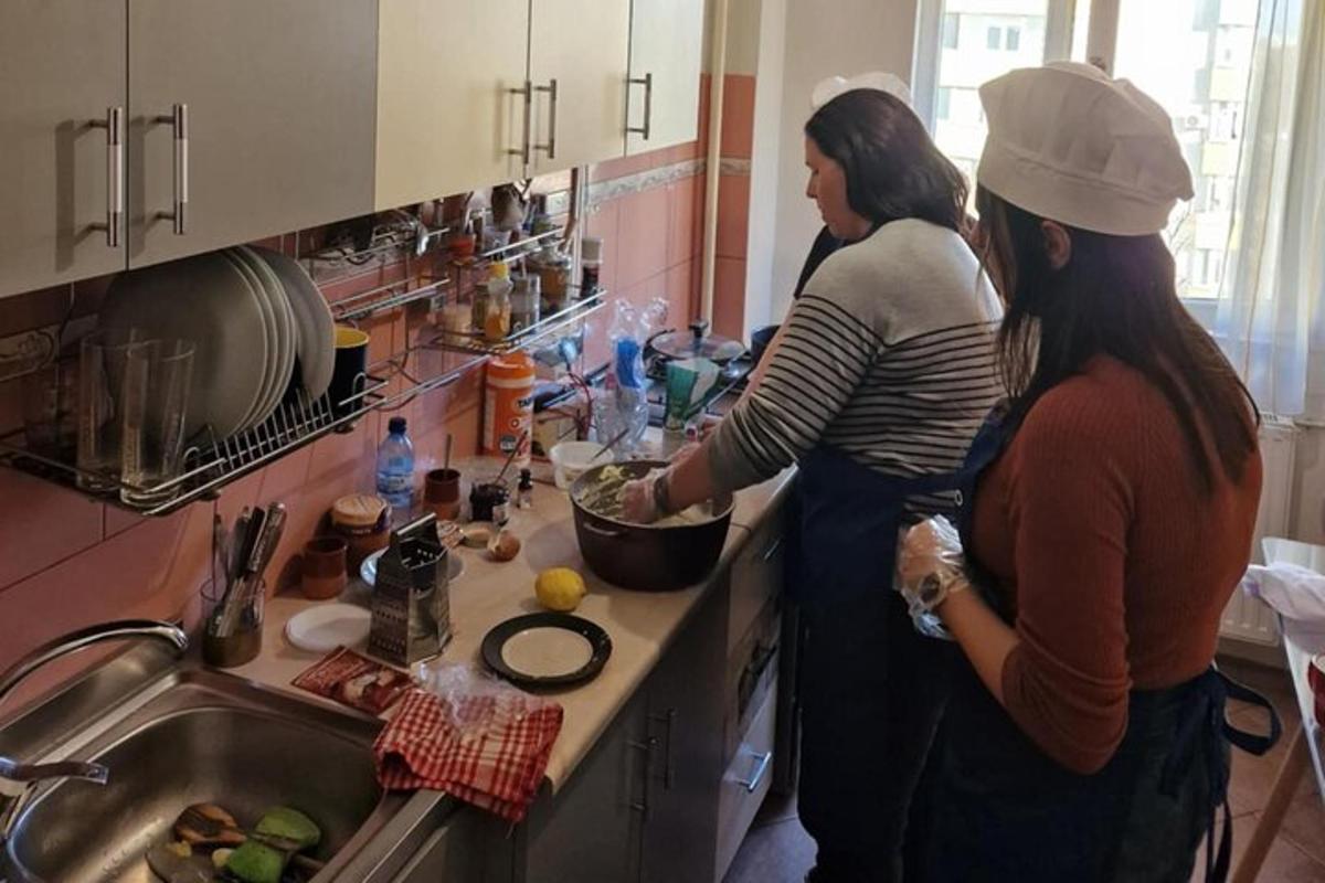 two women standing in a kitchen preparing food