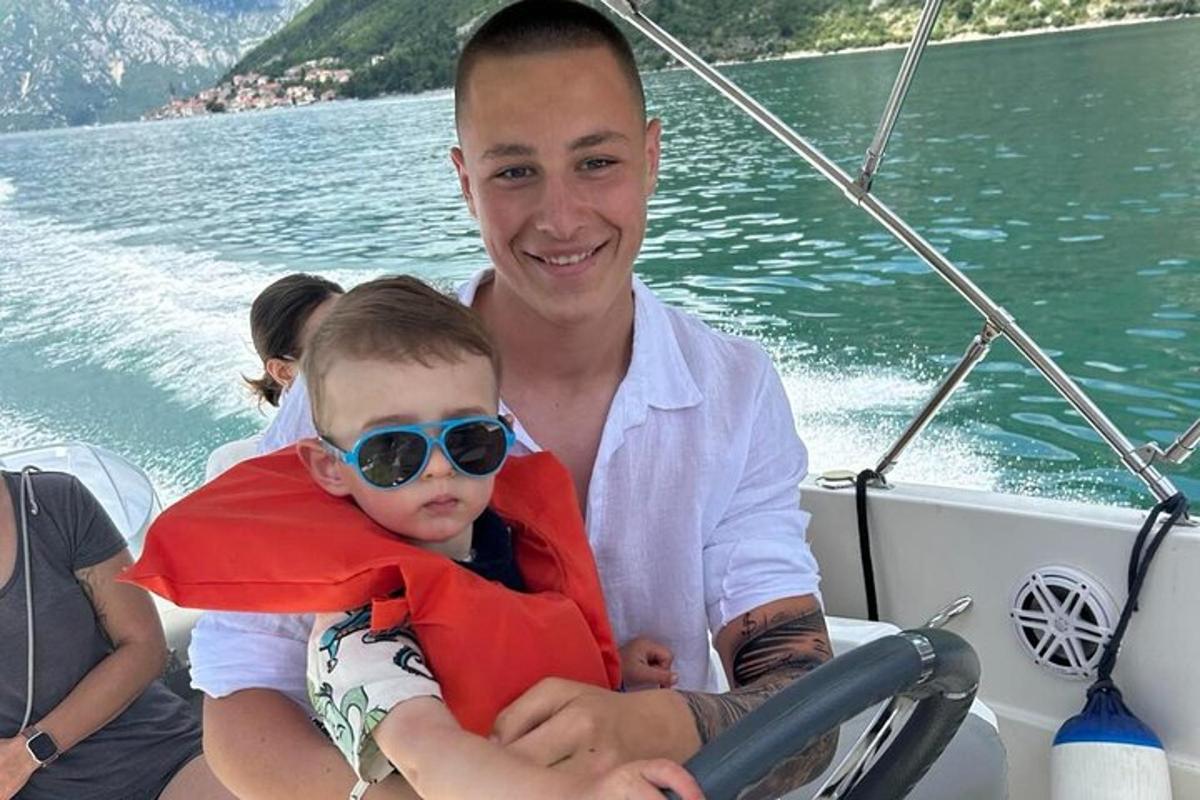 un uomo che tiene in braccio un ragazzino su una barca