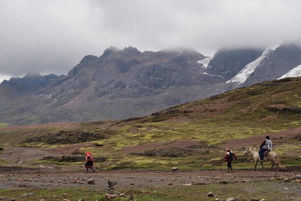a group of people riding horses on a mountain