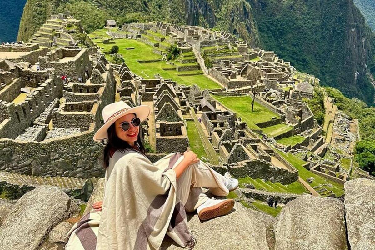 một người phụ nữ ngồi trên một tảng đá nhìn vào đống đổ nát