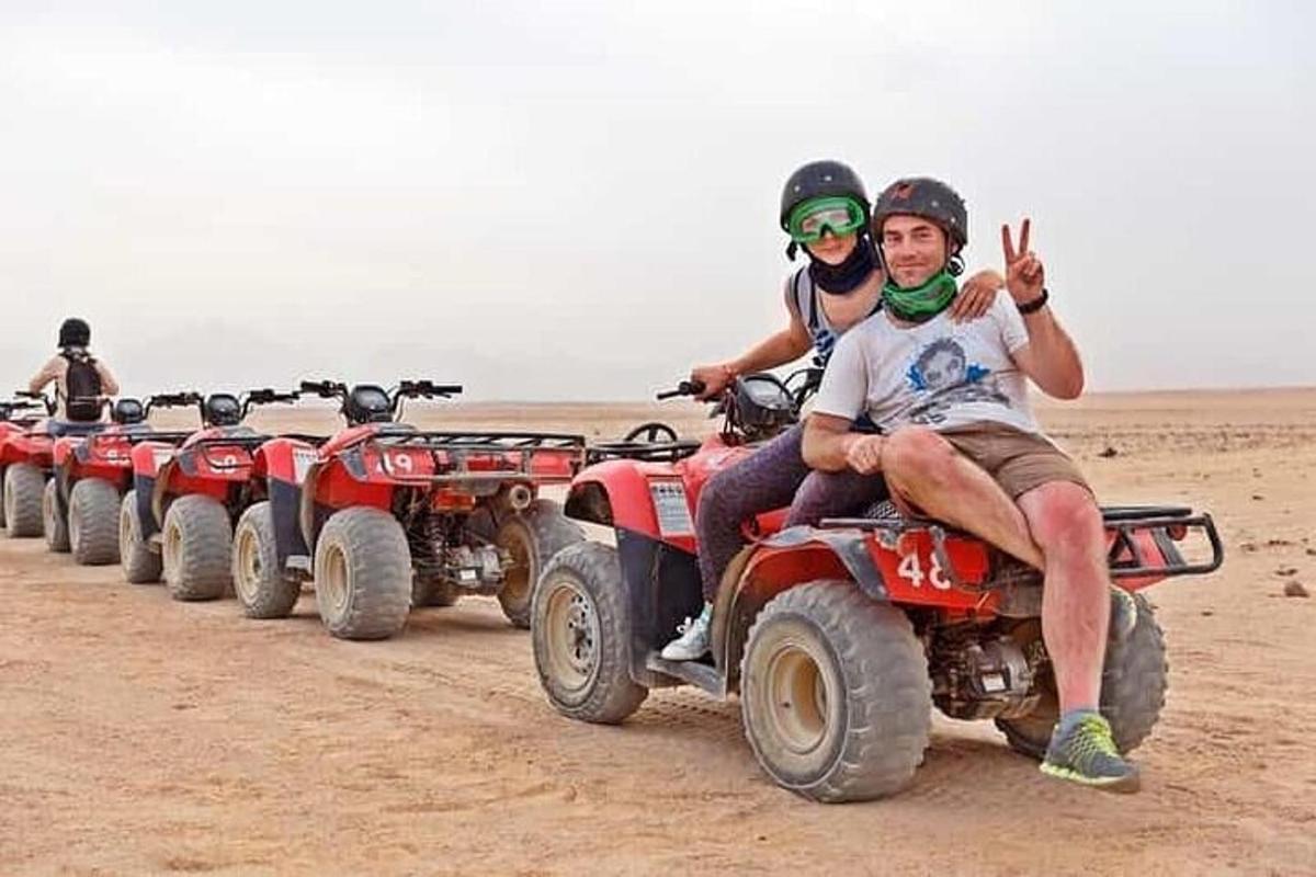Un grupo de personas conduciendo vehículos todo terreno en el desierto.