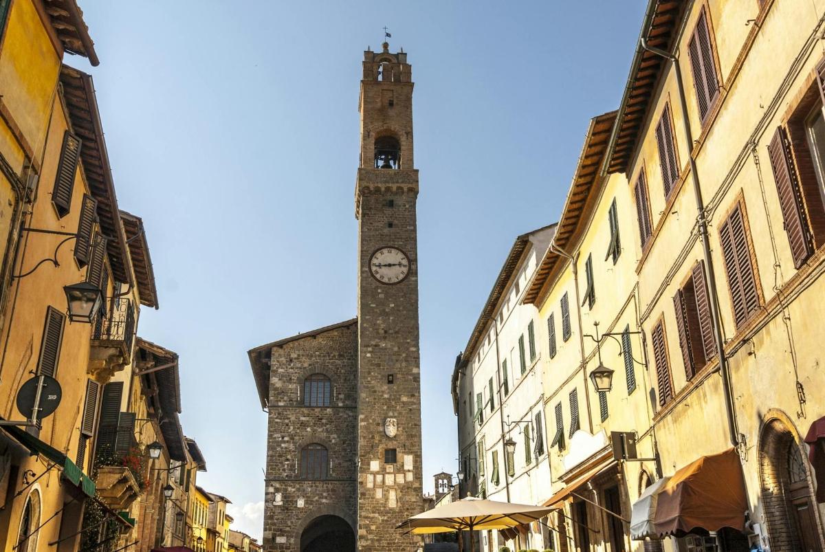 una torre alta con un orologio su un edificio