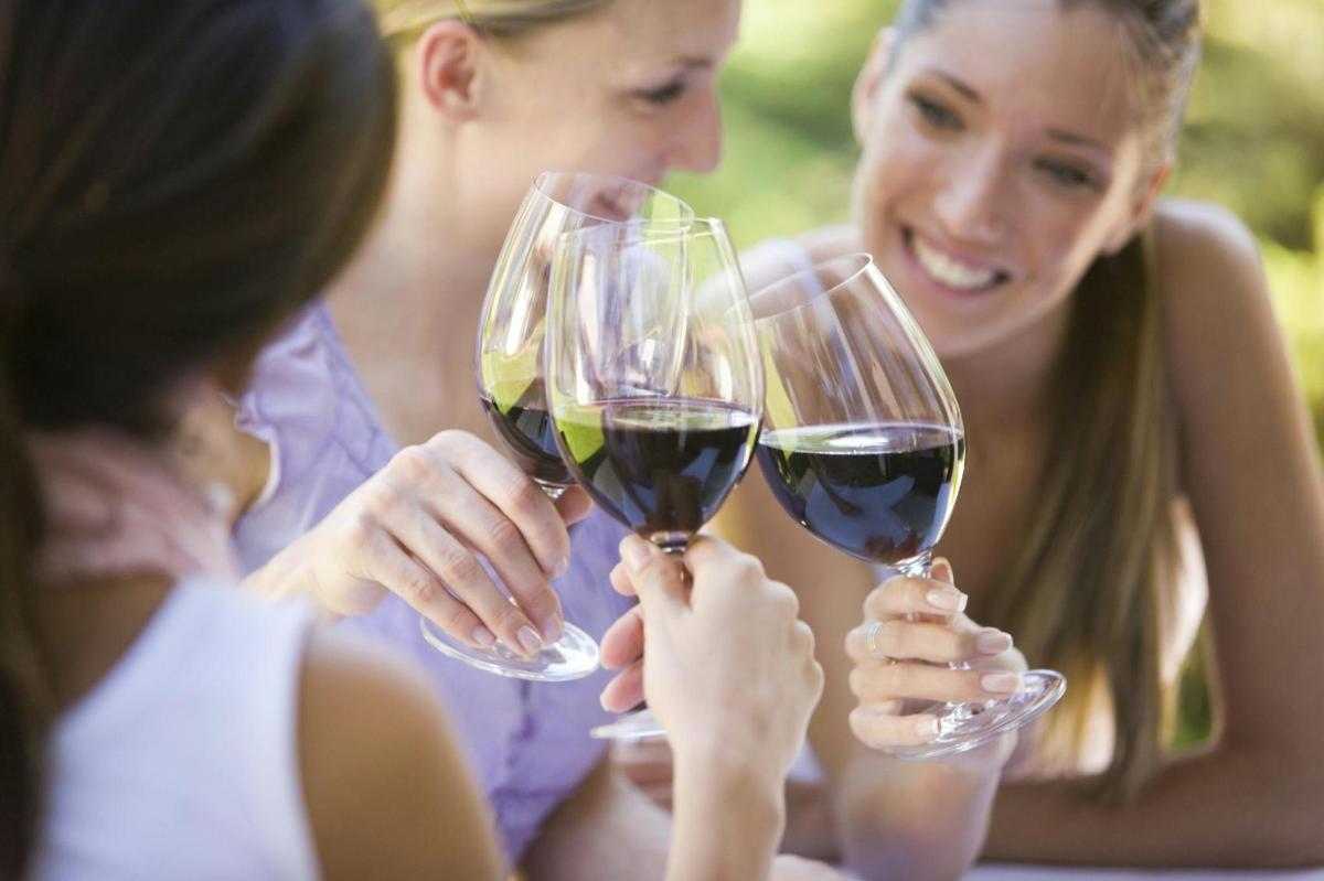 un gruppo di donne che sorreggono bicchieri di vino