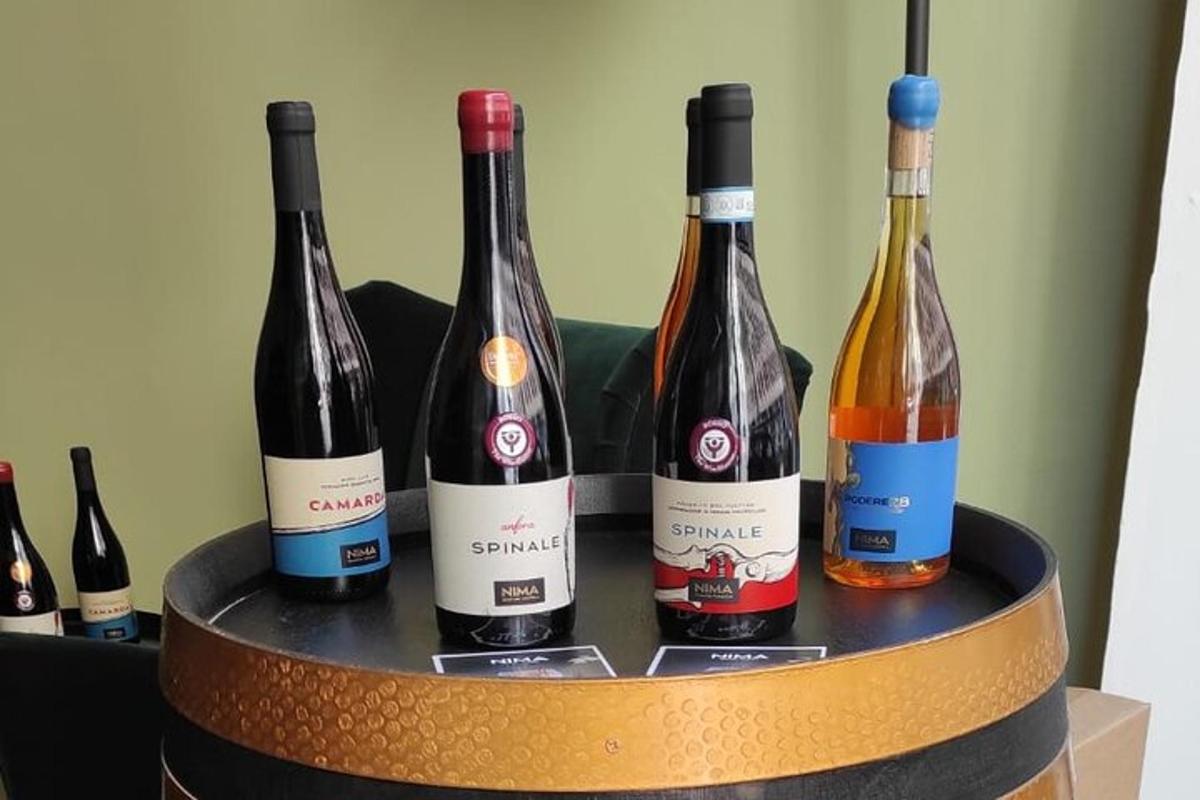 quattro bottiglie di vino appoggiate su una botte