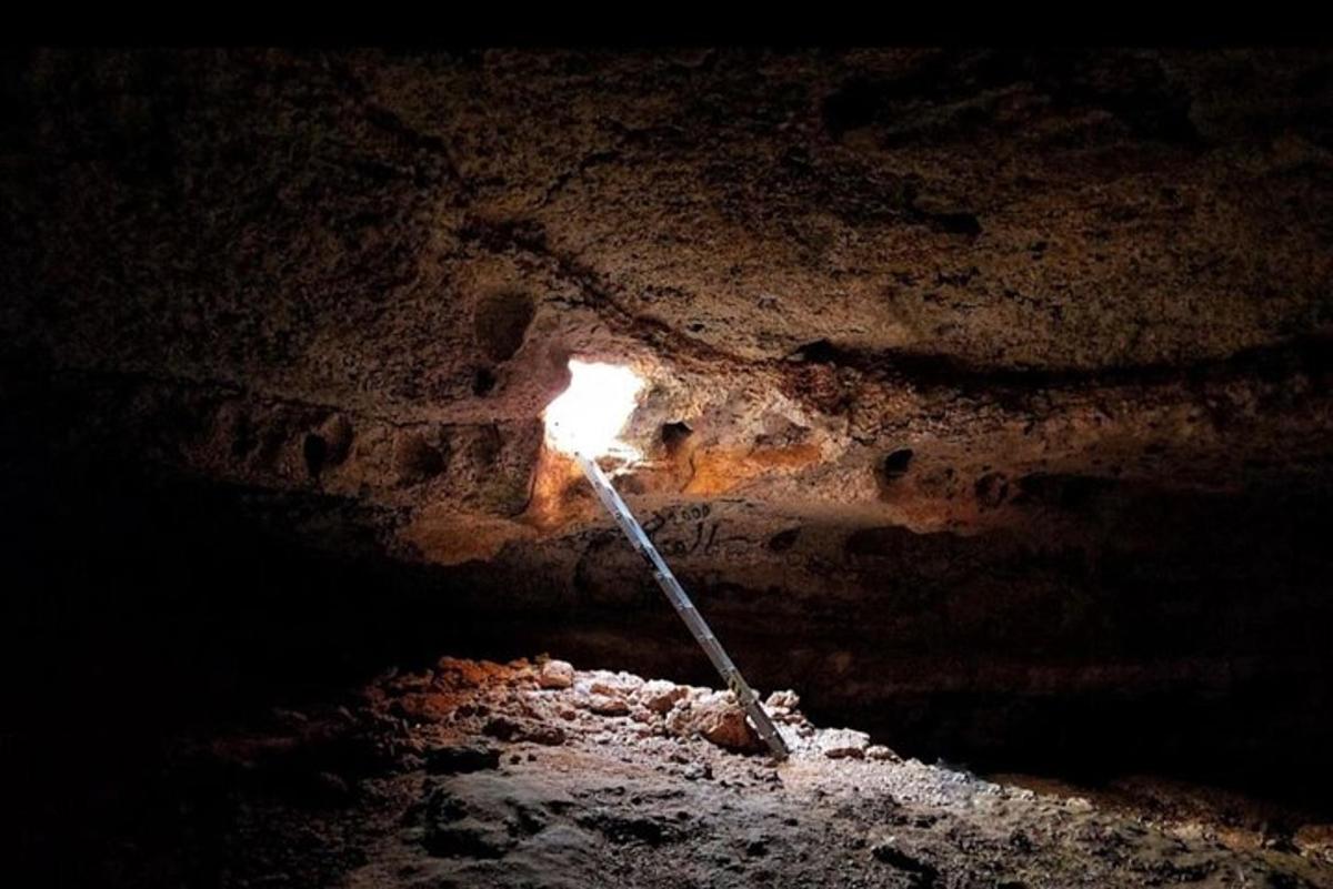a pole in a cave with a fire in it