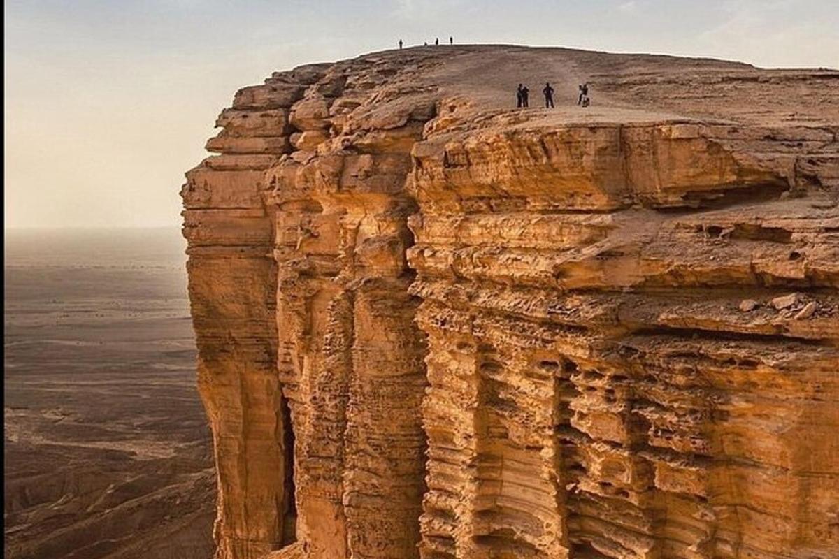 a group of people standing on top of a cliff