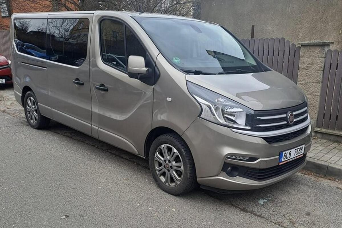 o dubă argintie parcată într-o parcare