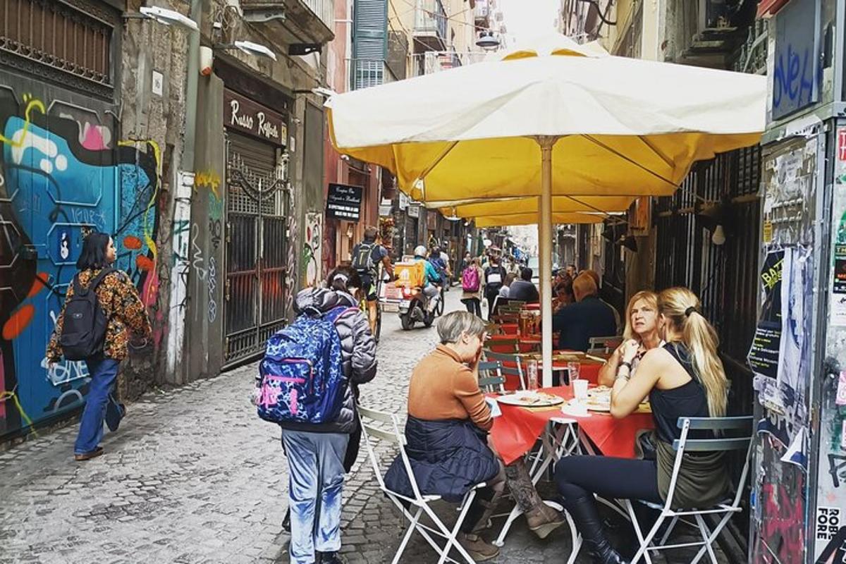 skupina lidí sedících u stolu pod slunečníkem