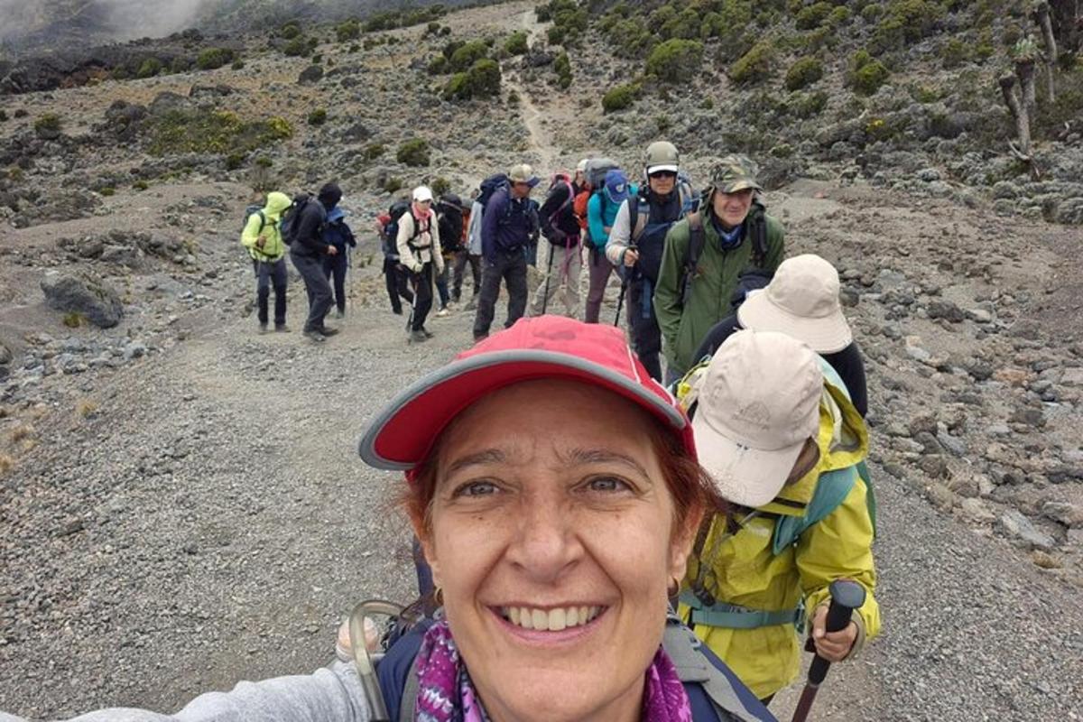 une femme debout sur une montagne avec un groupe de personnes