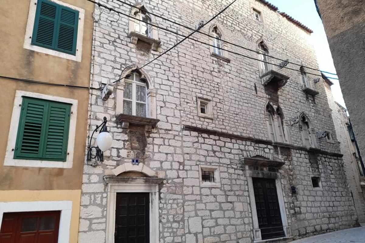 un antic edifici de pedra amb persianes verdes