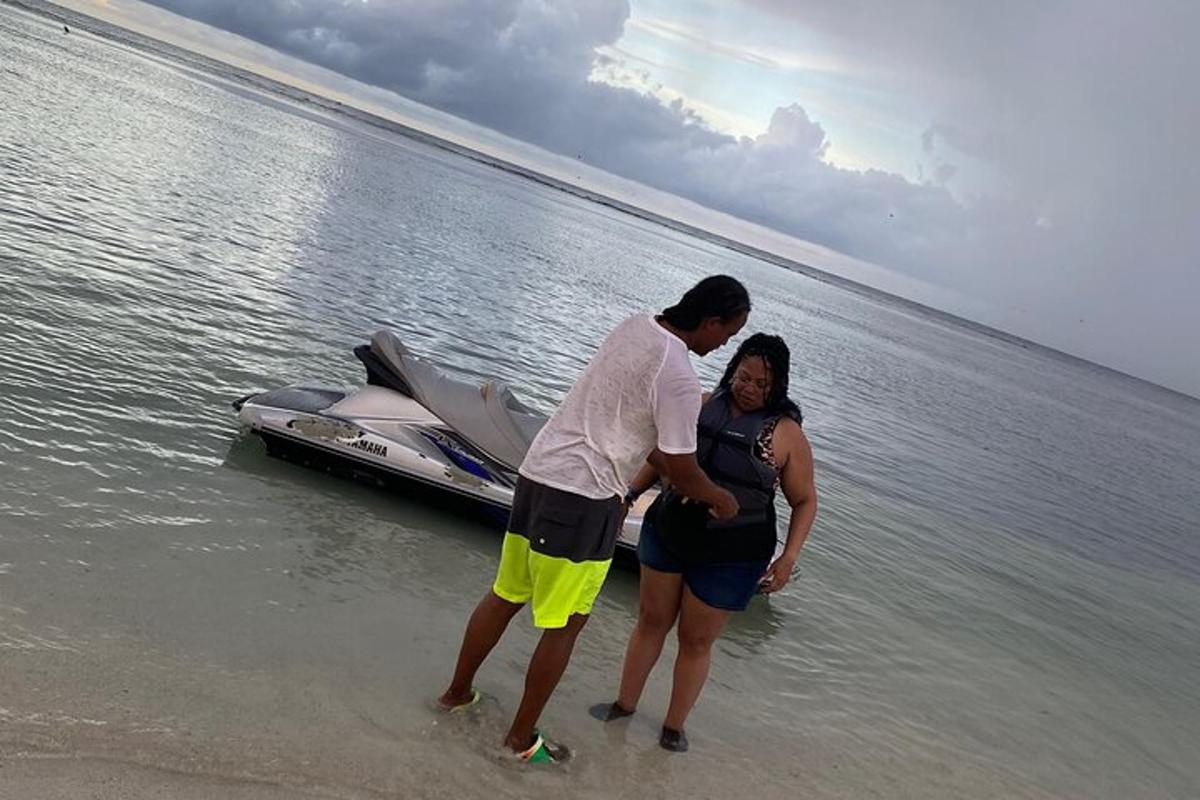um homem e uma mulher em pé na praia perto de um barco