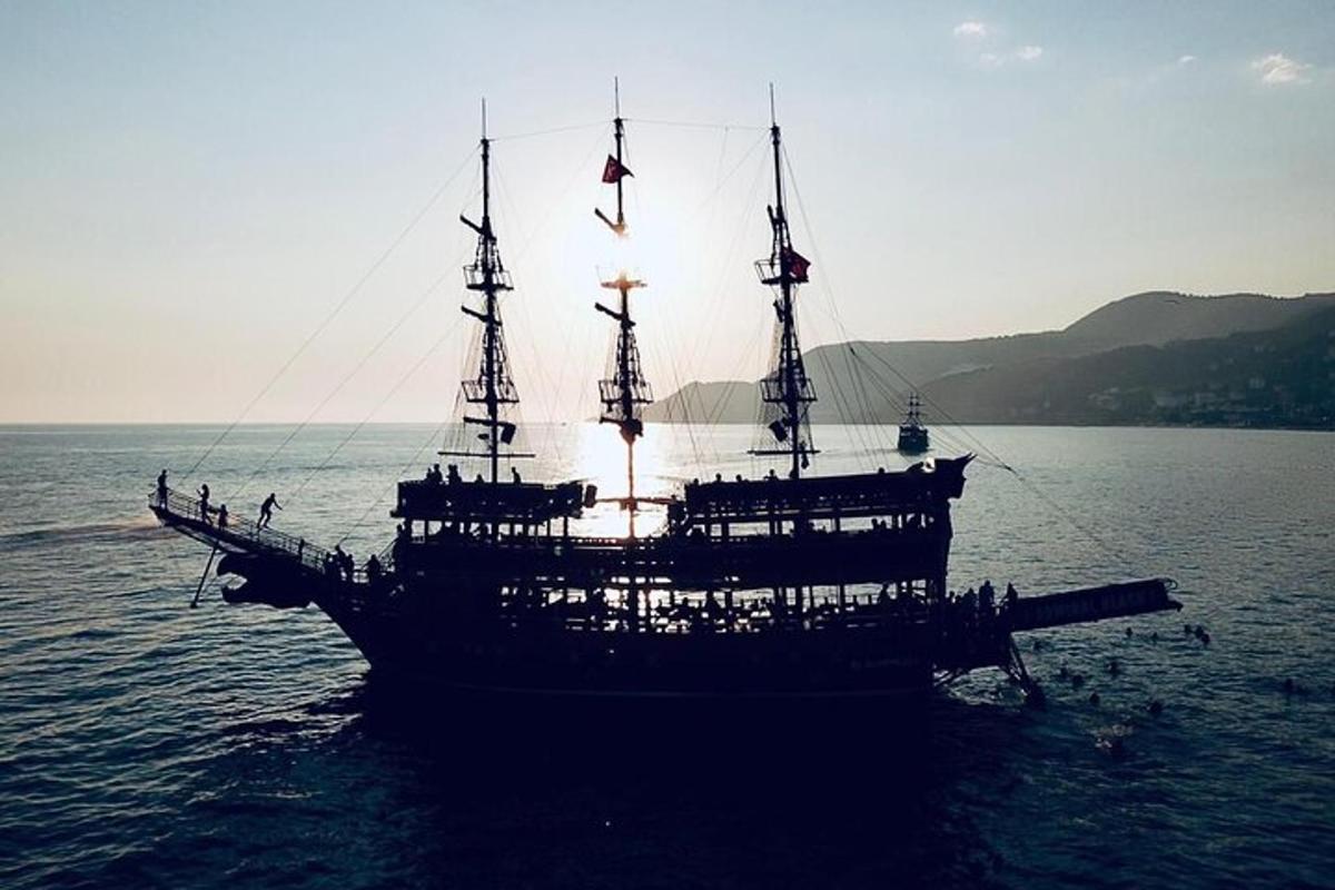 una grande barca in acqua con il sole che tramonta