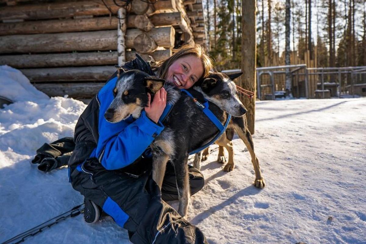 a woman is hugging two dogs in the snow