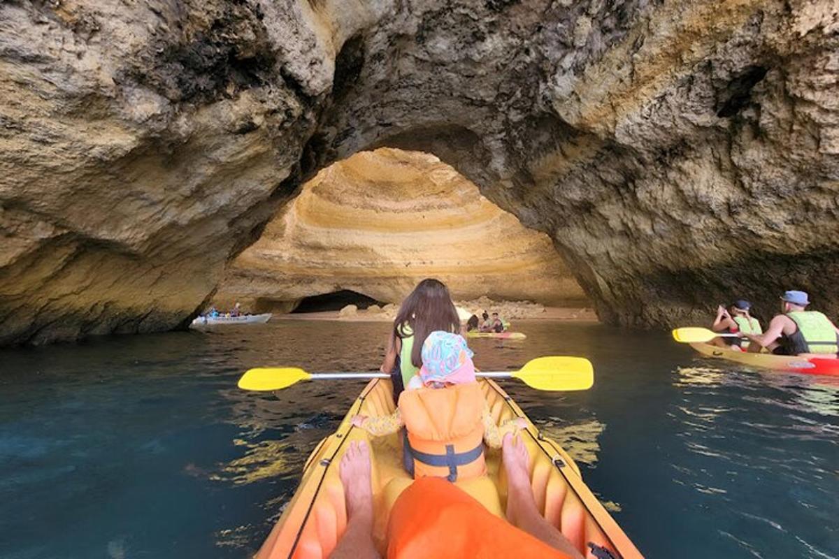a woman in a kayak in front of a cave
