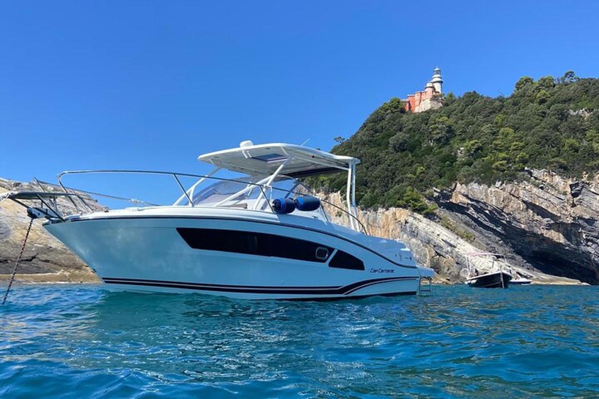 a white boat sitting in the water near a mountain