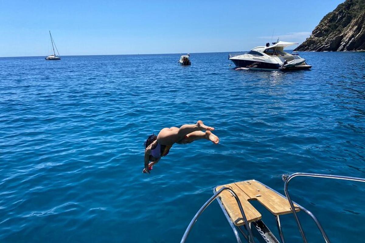 a man jumping off of a boat in the water