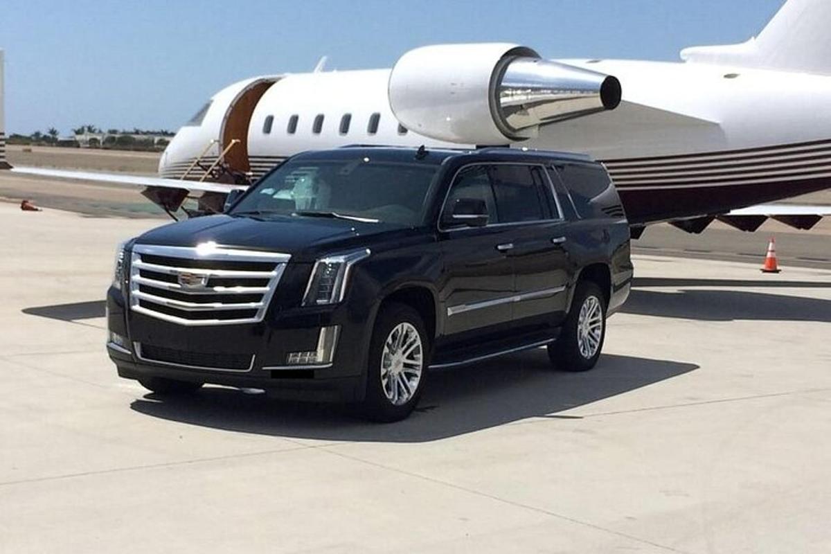 Un camión negro está estacionado al lado de un avión.
