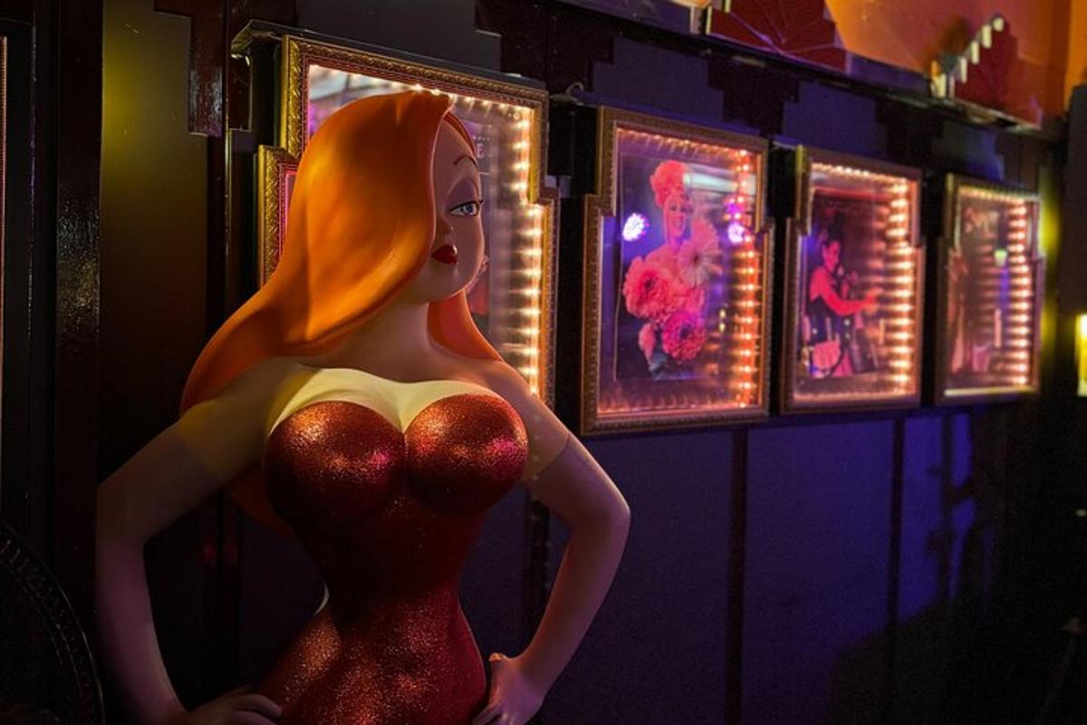 uma boneca de vestido vermelho em uma sala com luzes