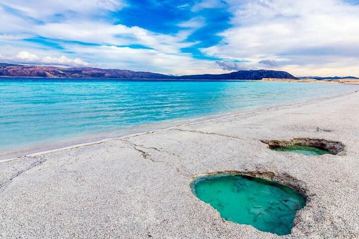 una spiaggia con due buchi nella sabbia e nell'acqua