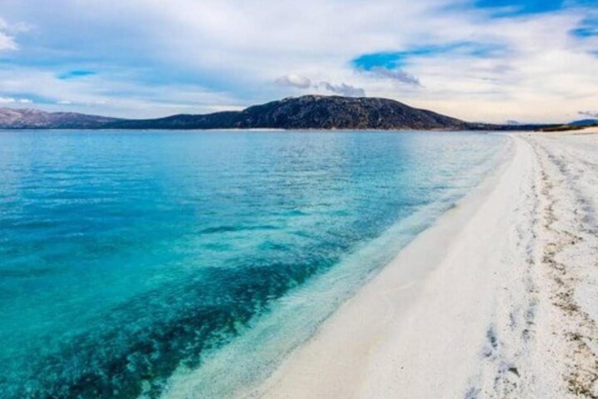 plaža z belim peskom in modro vodo