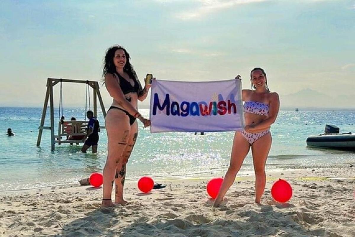 Dvě ženy v plavkách držící ceduli na pláži
