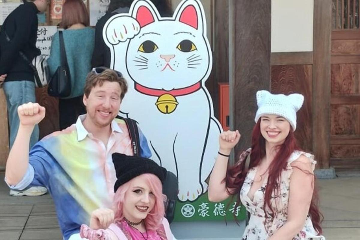 一群人在猫咪标志前摆姿势