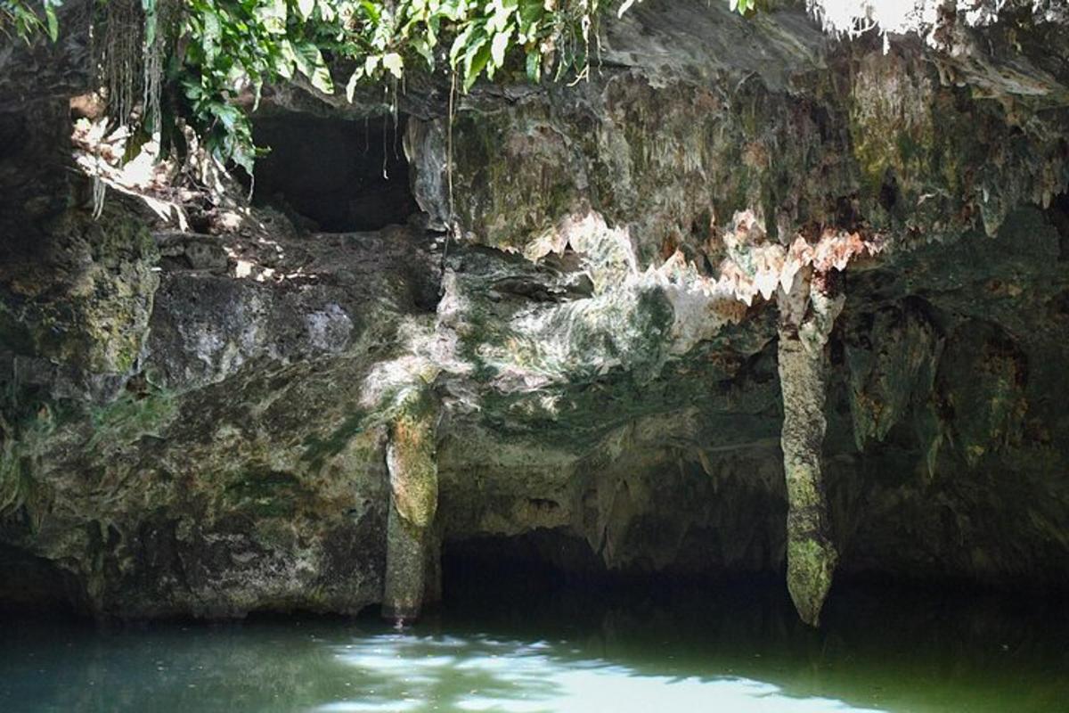 uma caverna com água verde e uma parede de rocha