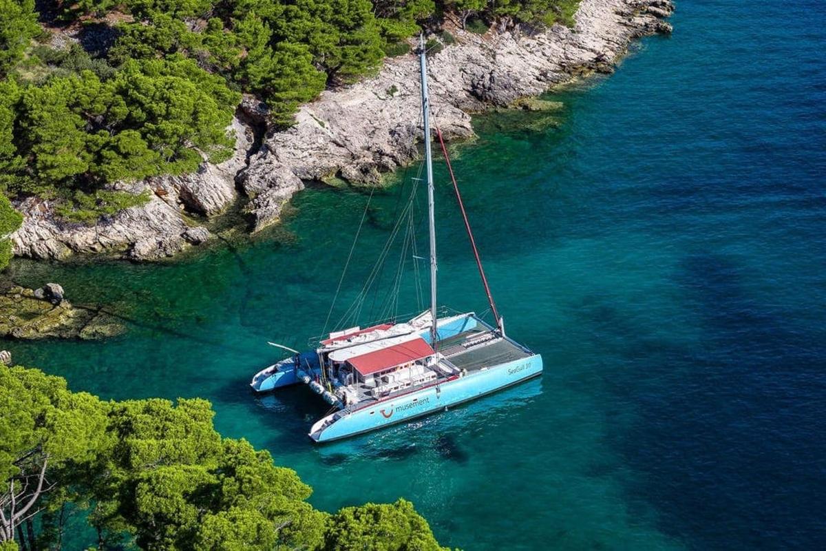 a boat floating in the water next to a cliff