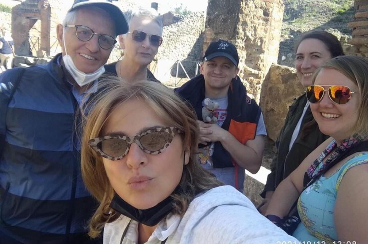 skupina lidí stojící kolem ženy se slunečními brýlemi
